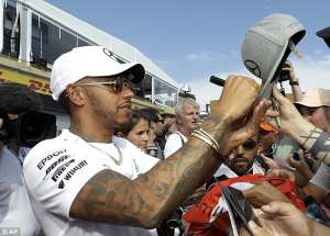 a man in a military uniform: Hamilton signs autographs for fans ahead of the French Grand Prix this weekend