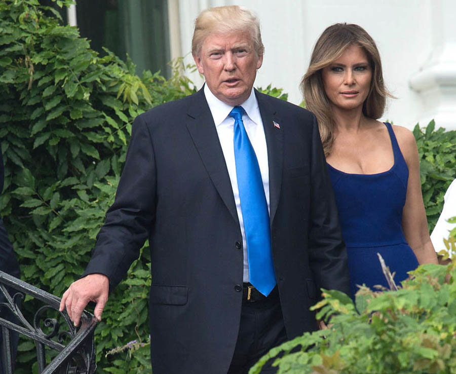 Donald Trump and First Lady Melania Trump walk down the stairs to greet guests  during the military families picnic at the White House