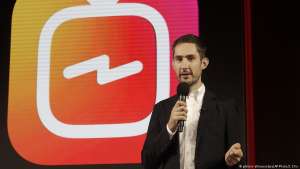 Kevin Systrom holding a sign posing for the camera