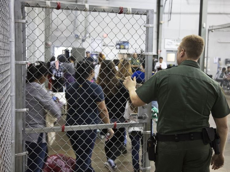 A Border Patrol agent watches detainees
