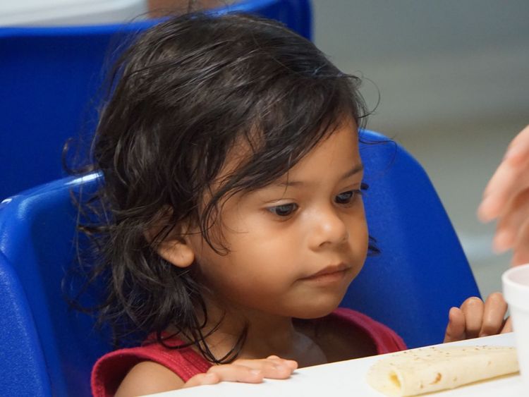 A young girl is given some soup at a migration centre in Texas